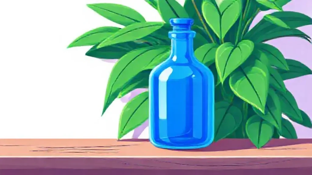Una botella azul junto a una planta verde