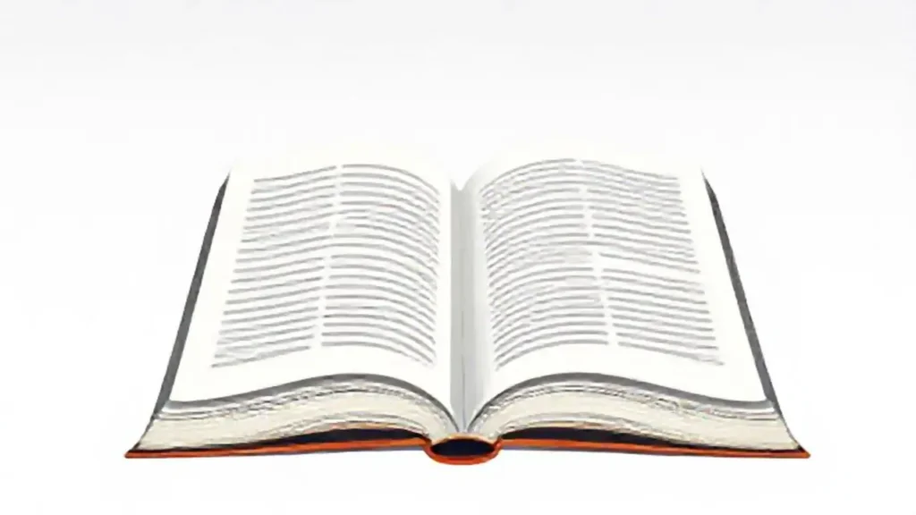 Un tubo blanco junto a un libro abierto