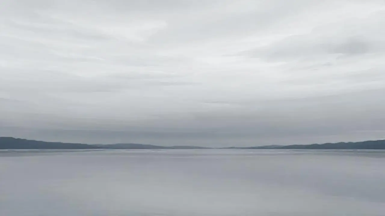 Cielo gris sobre un lago sereno
